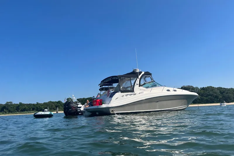 Slide: The Image of 2007 Sea Ray 340 Sundancer boat anchored on calm water under clear blue sky. - 3