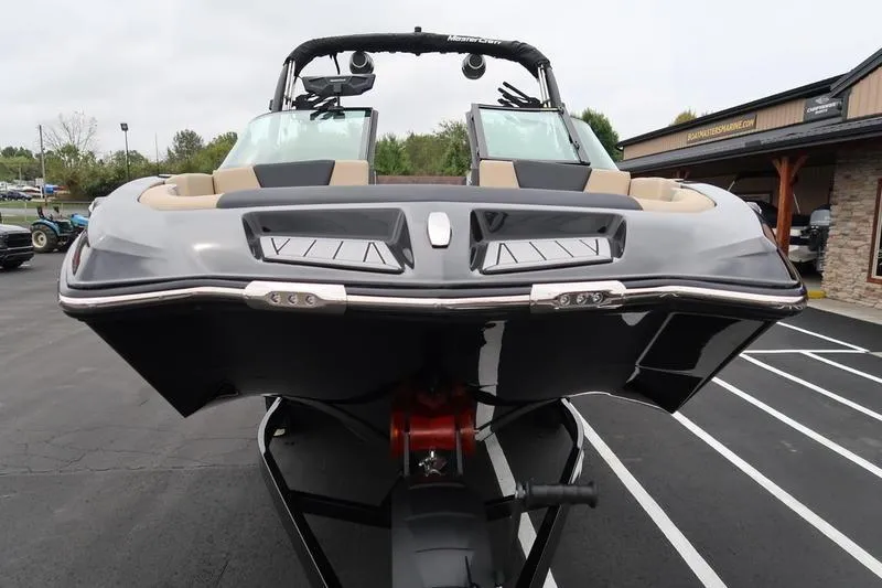 Slide: The Image of 2025 MasterCraft XT22 boat on trailer, front view, parked outdoors. - 10