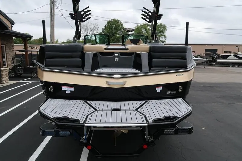 Slide: The Image of 2025 MasterCraft XT22 boat, rear view, showcasing sleek design and spacious deck. - 11