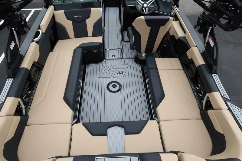 Slide: The Image of 2025 MasterCraft XT22 boat interior with beige and black seating, sleek design, and modern features. - 15
