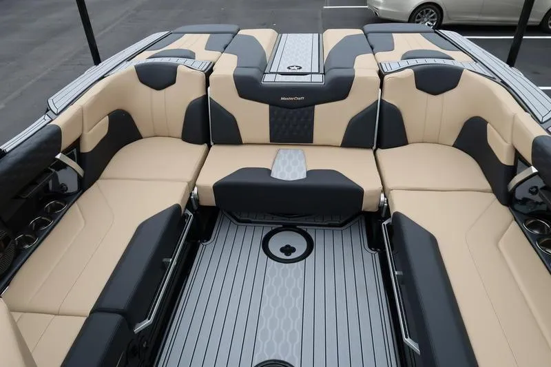 Slide: The Image of 2025 MasterCraft XT22 boat interior with beige and black seating, modern design. - 16