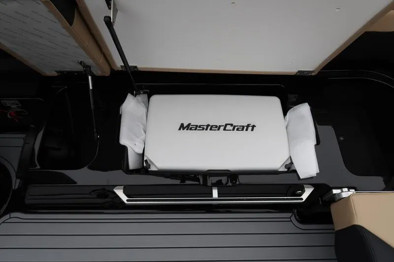 Slide: The Image of 2025 MasterCraft XT22 boat storage compartment with branded cushion. - 21