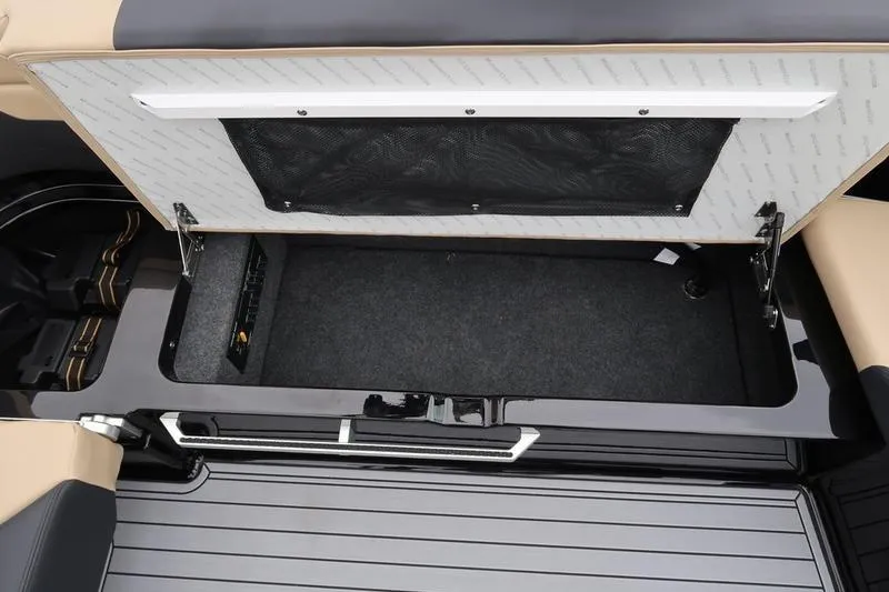 Slide: The Image of 2025 MasterCraft XT22 storage compartment with open lid, showcasing interior space and design. - 22