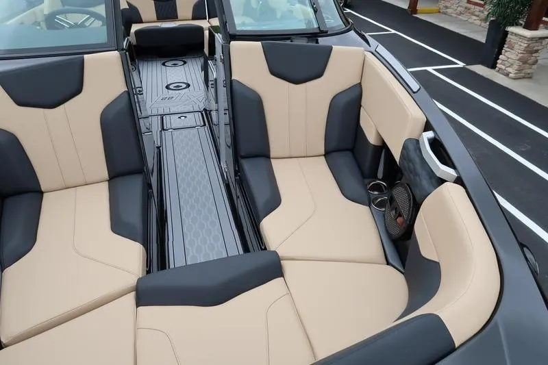 Slide: The Image of 2025 MasterCraft XT22 boat interior with beige and black seating, modern design. - 23
