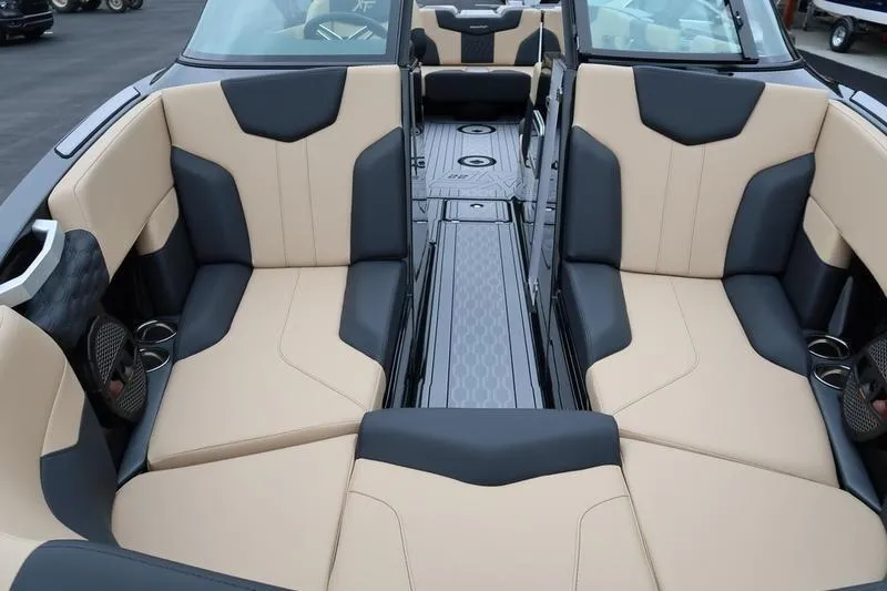 Slide: The Image of 2025 MasterCraft XT22 boat interior with beige and black seating, spacious layout. - 24