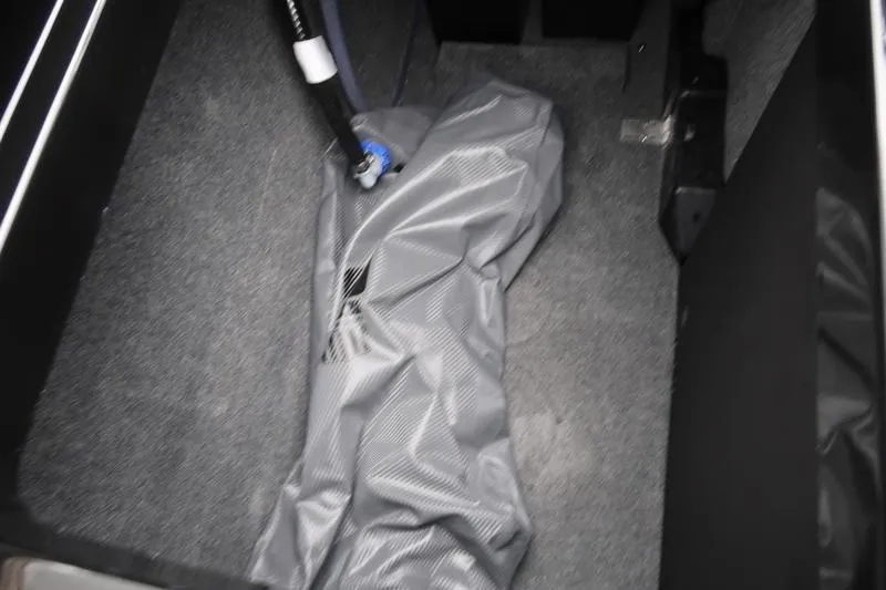 Slide: The Image of Interior view of 2025 MasterCraft XT22 boat storage compartment with gray cover. - 26