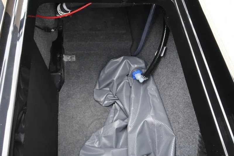 Slide: The Image of Interior storage compartment of 2025 MasterCraft XT22 boat with hose and fabric cover. - 28