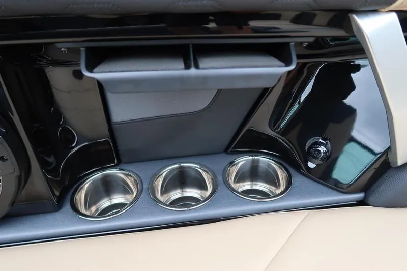 Slide: The Image of 2025 MasterCraft XT22 interior with cup holders and sleek black finish. - 34