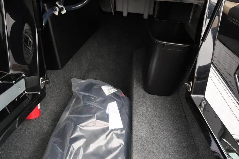 Slide: The Image of 2025 MasterCraft XT22 interior storage area with carpeted flooring and equipment. - 37