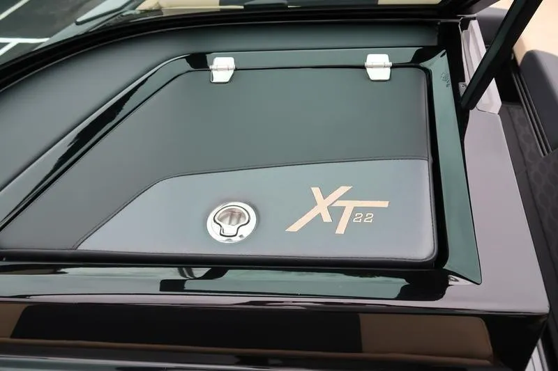 Slide: The Image of 2025 MasterCraft XT22 boat compartment with sleek black design and logo. - 41