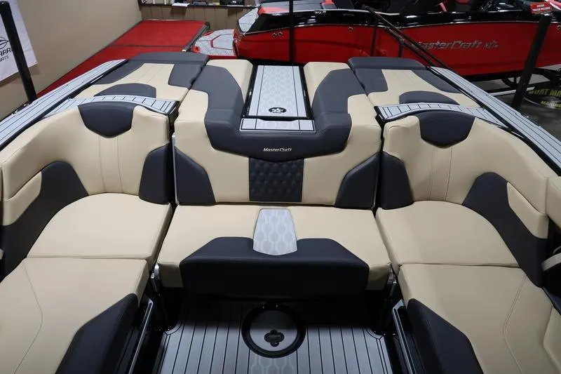 Slide: The Image of 2025 MasterCraft XT22 boat interior with beige and black seating, showcasing luxury design. - 51