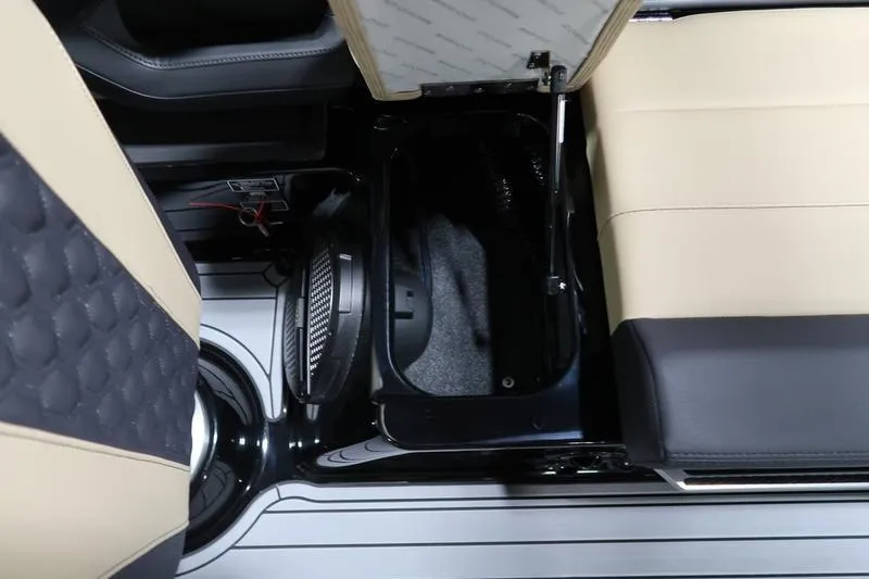 Slide: The Image of 2025 MasterCraft XT22 interior storage compartment with beige and black seating. - 59