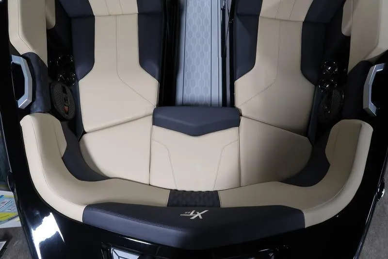 Slide: The Image of 2025 MasterCraft XT22 boat interior with beige and black seating, showcasing modern design. - 60