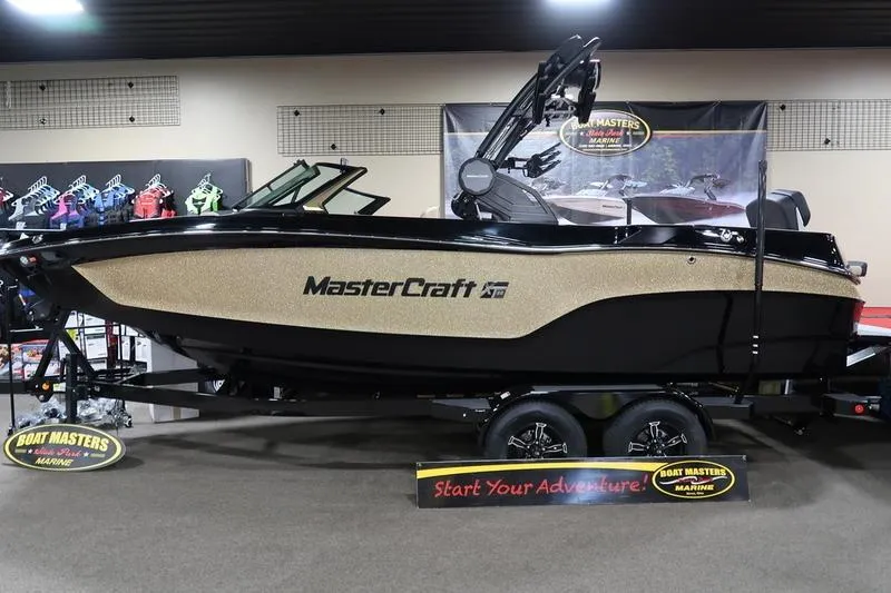 Slide: The Image of 2025 MasterCraft XT22 boat displayed indoors on a trailer. - 66