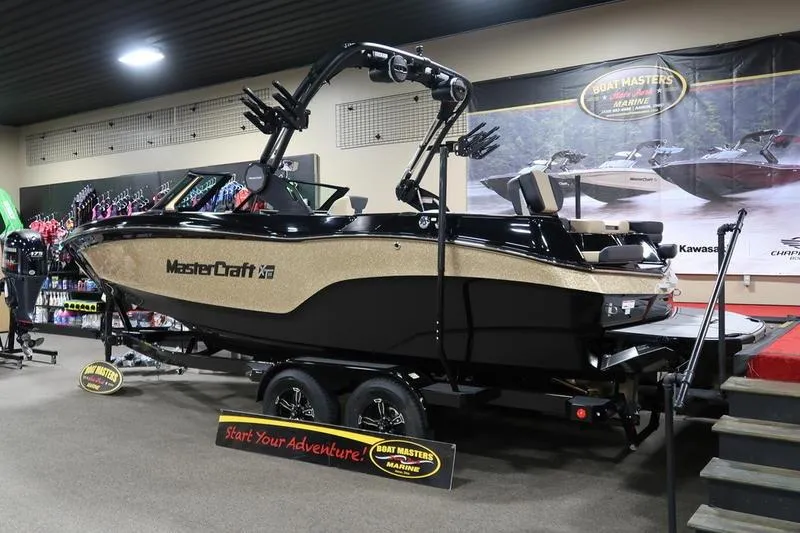 Slide: The Image of 2025 MasterCraft XT22 boat displayed indoors at Boat Masters Marine showroom. - 67