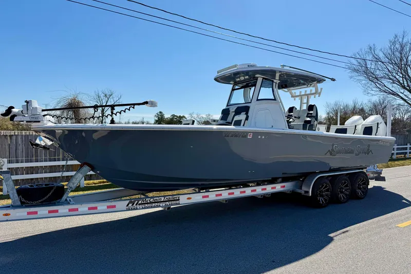 The Image of 2024 Tidewater 3100 Carolina Bay boat on trailer, parked on a sunny street. - 1