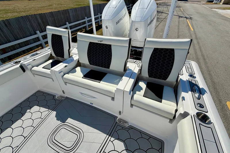 Slide: The Image of 2024 Tidewater 3100 Carolina Bay boat interior with seating and dual Mercury engines. - 7