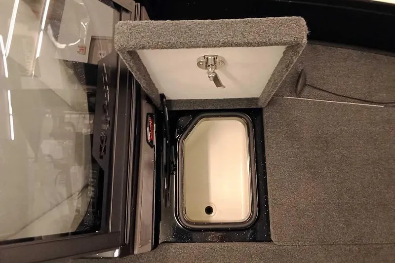 Slide: The Image of 2026 Ranger 620xFS Pro boat storage compartment with open lid and carpeted interior. - 16