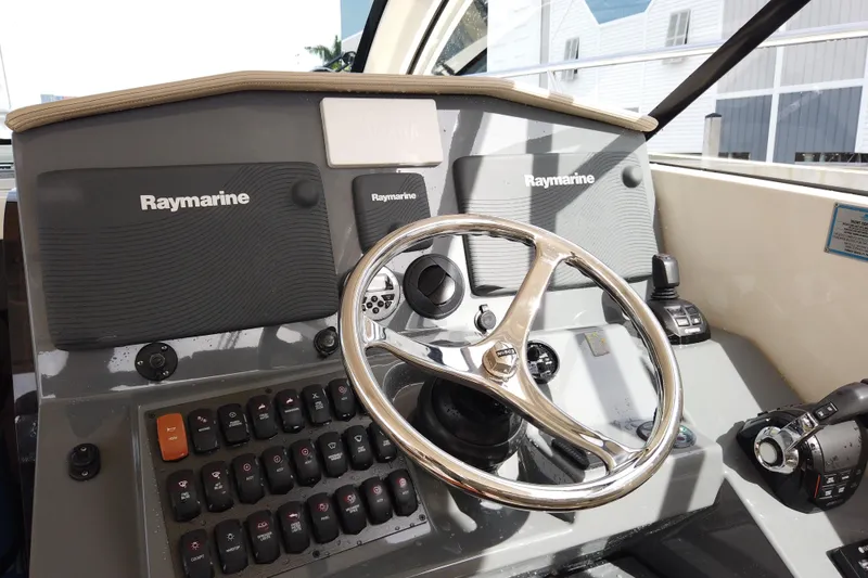 Slide: The Image of 2014 Pursuit SC 365i Sport Coupe helm with Raymarine electronics and steering wheel. - 17