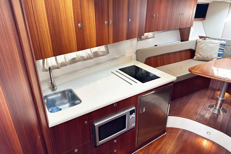 Slide: The Image of 2014 Pursuit SC 365i Sport Coupe interior with kitchenette, sink, and seating area. - 19
