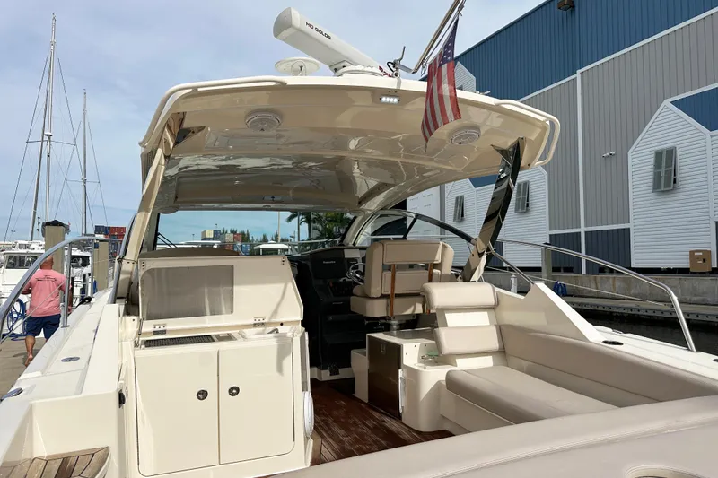 Slide: The Image of 2014 Pursuit SC 365i Sport Coupe yacht docked at marina, featuring spacious seating and helm. - 8