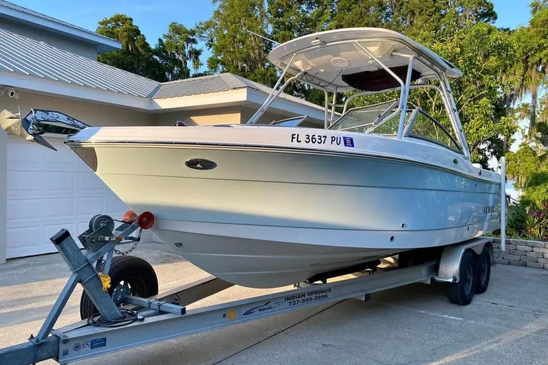 Slide: The Image of 2015 Robalo R247 Dual Console boat on trailer, parked in driveway. - 0
