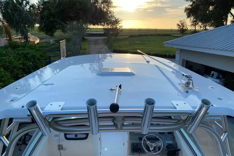 Slide: The Image of 2015 Robalo R247 Dual Console boat with rod holders, scenic sunset view. - 4