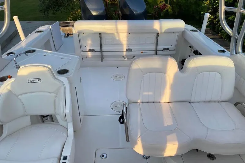 Slide: The Image of 2015 Robalo R247 Dual Console boat interior with white seating and helm station. - 6
