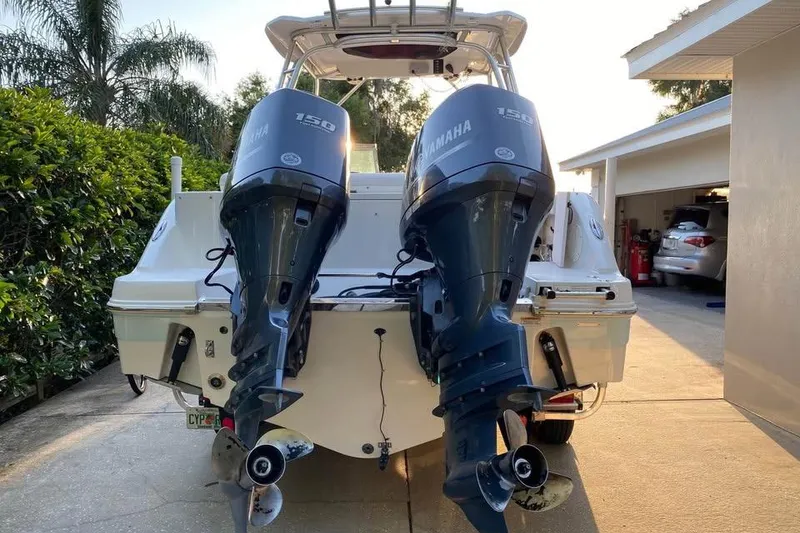 Slide: The Image of 2015 Robalo R247 Dual Console with twin Yamaha 150 engines in driveway. - 8