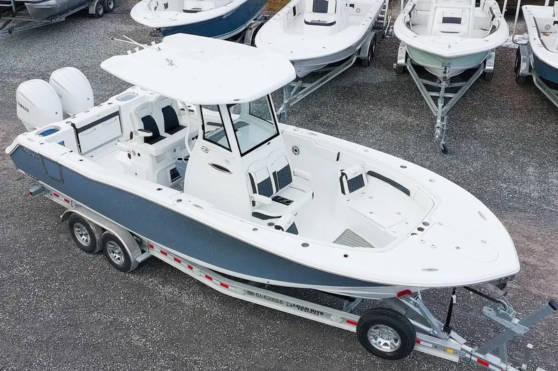 Slide: The Image of 2026 Tidewater 282 CC Adventure boat on trailer, surrounded by other boats. - 3