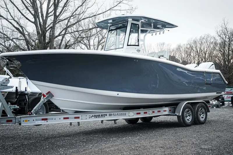 Slide: The Image of 2026 Tidewater 282 CC Adventure boat on trailer, parked outdoors. - 5