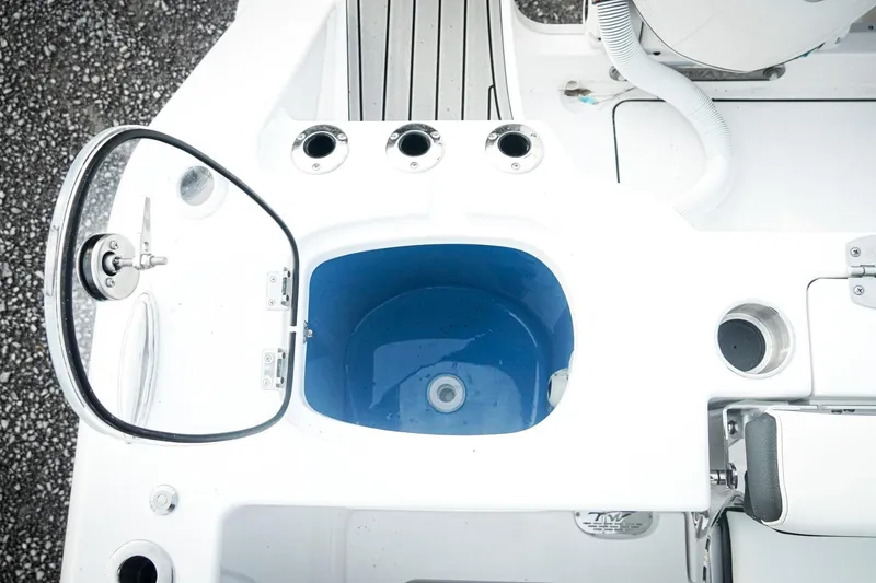 Slide: The Image of 2026 Tidewater 282 CC Adventure boat interior with blue livewell and rod holders. - 50