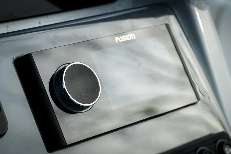 Slide: The Image of 2026 Tidewater 282 CC Adventure boat dashboard with Fusion audio control panel. - 56