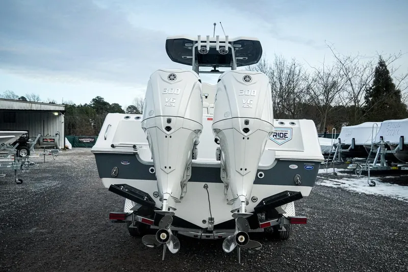 Slide: The Image of 2026 Tidewater 282 CC Adventure boat with dual Yamaha 300 V6 engines, parked outdoors. - 6