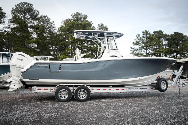 Slide: The Image of 2026 Tidewater 282 CC Adventure boat on trailer, parked outdoors near trees. - 65