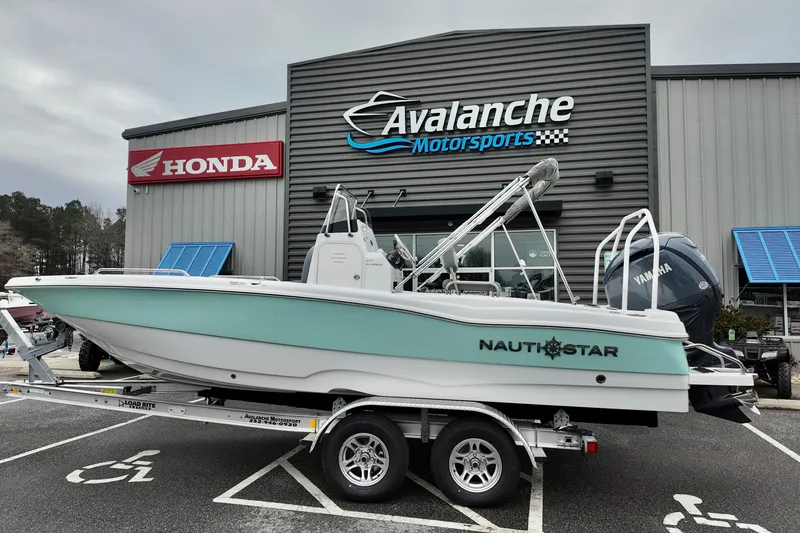 The Image of 2025 NauticStar 211 Hybrid boat on trailer at Avalanche Motorsports dealership. - 0