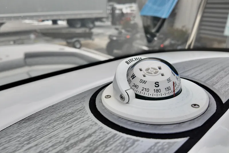 Slide: The Image of Compass on 2025 NauticStar 211 Hybrid boat dashboard, close-up view. - 11
