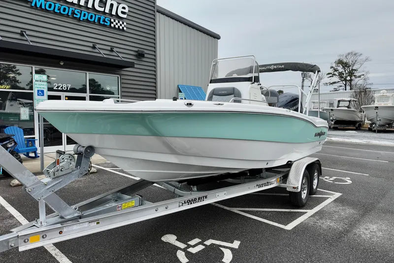 Slide: The Image of 2025 NauticStar 211 Hybrid boat on trailer at dealership parking lot. - 15