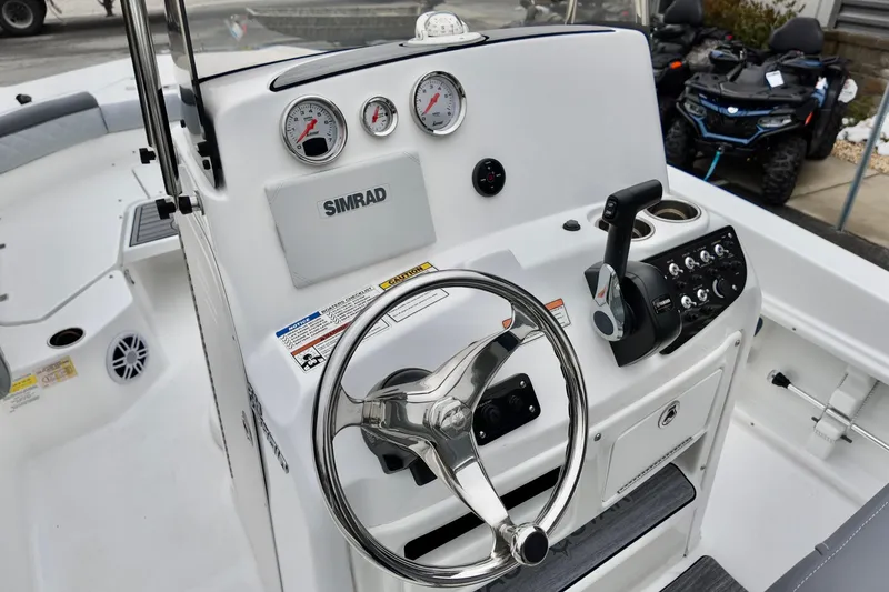 Slide: The Image of 2025 NauticStar 211 Hybrid boat dashboard with steering wheel and control panel. - 6