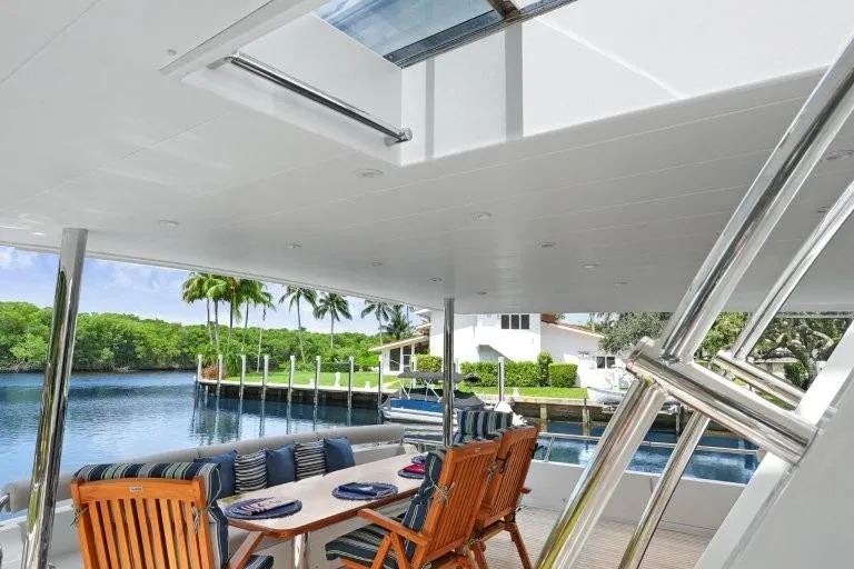 Slide: The Image of Luxurious 2003 Hargrave Sky Lounge yacht with elegant outdoor dining area and scenic waterfront view. - 5