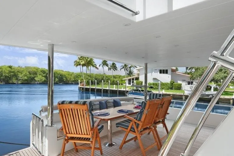 Slide: The Image of Outdoor dining area on 2003 Hargrave Sky Lounge yacht, overlooking serene waterfront and lush greenery. - 7