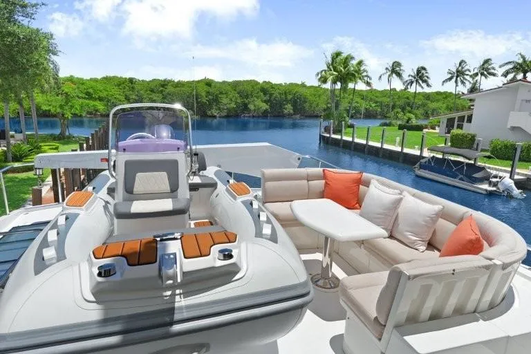 Slide: The Image of Luxurious 2003 Hargrave Sky Lounge yacht with elegant seating, docked by a scenic waterfront. - 78