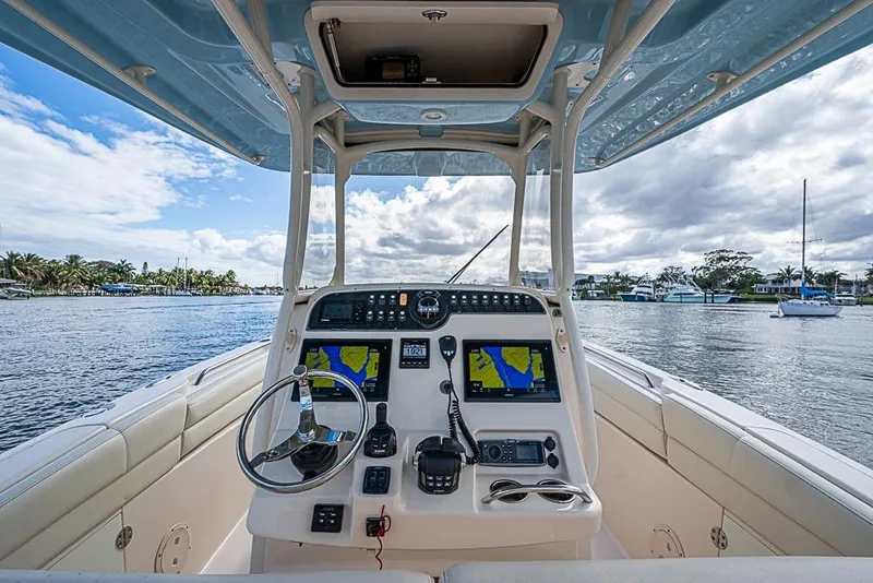 Slide: The Image of 2016 Grady-White Canyon 271 FS boat helm with navigation screens on a sunny day. - 13