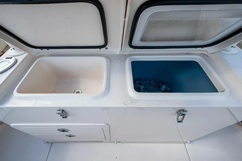 Slide: The Image of 2016 Grady-White Canyon 271 FS boat storage compartments with open lids. - 9