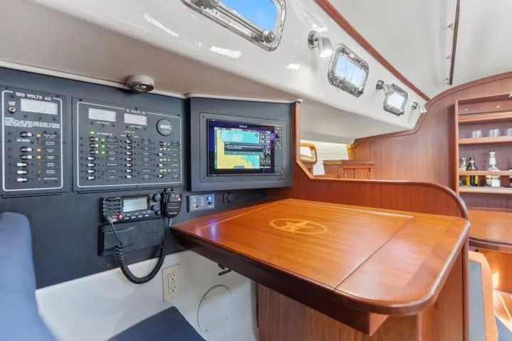 Slide: The Image of Interior of 2015 Blue Jacket 40 sailboat with navigation panel and wooden table. - 14