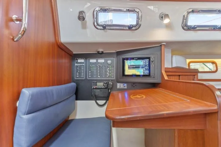 Slide: The Image of Navigation station in 2015 Blue Jacket 40 sailboat with control panel and seating. - 15
