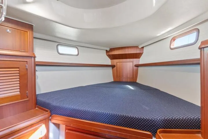 Slide: The Image of Interior cabin of 2015 Blue Jacket 40 sailboat with wooden finish and cozy bedding. - 19