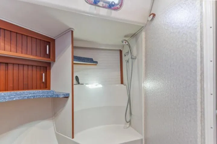 Slide: The Image of Shower area in 2015 Blue Jacket 40 sailboat with wooden cabinets and blue countertops. - 21