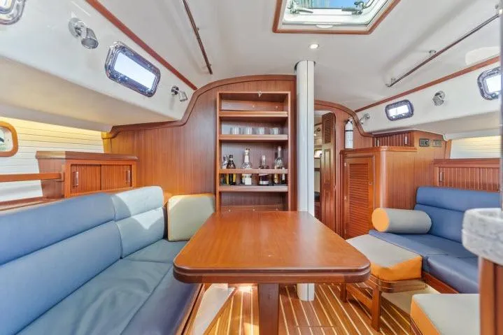 Slide: The Image of Interior of 2015 Blue Jacket 40 sailboat with wooden furnishings and seating area. - 4