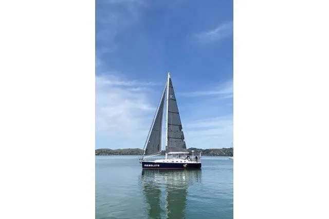Slide: The Image of Sailboat "Resolute" on calm water, Blue Jacket 40 model, 2015, under clear blue sky. - 57